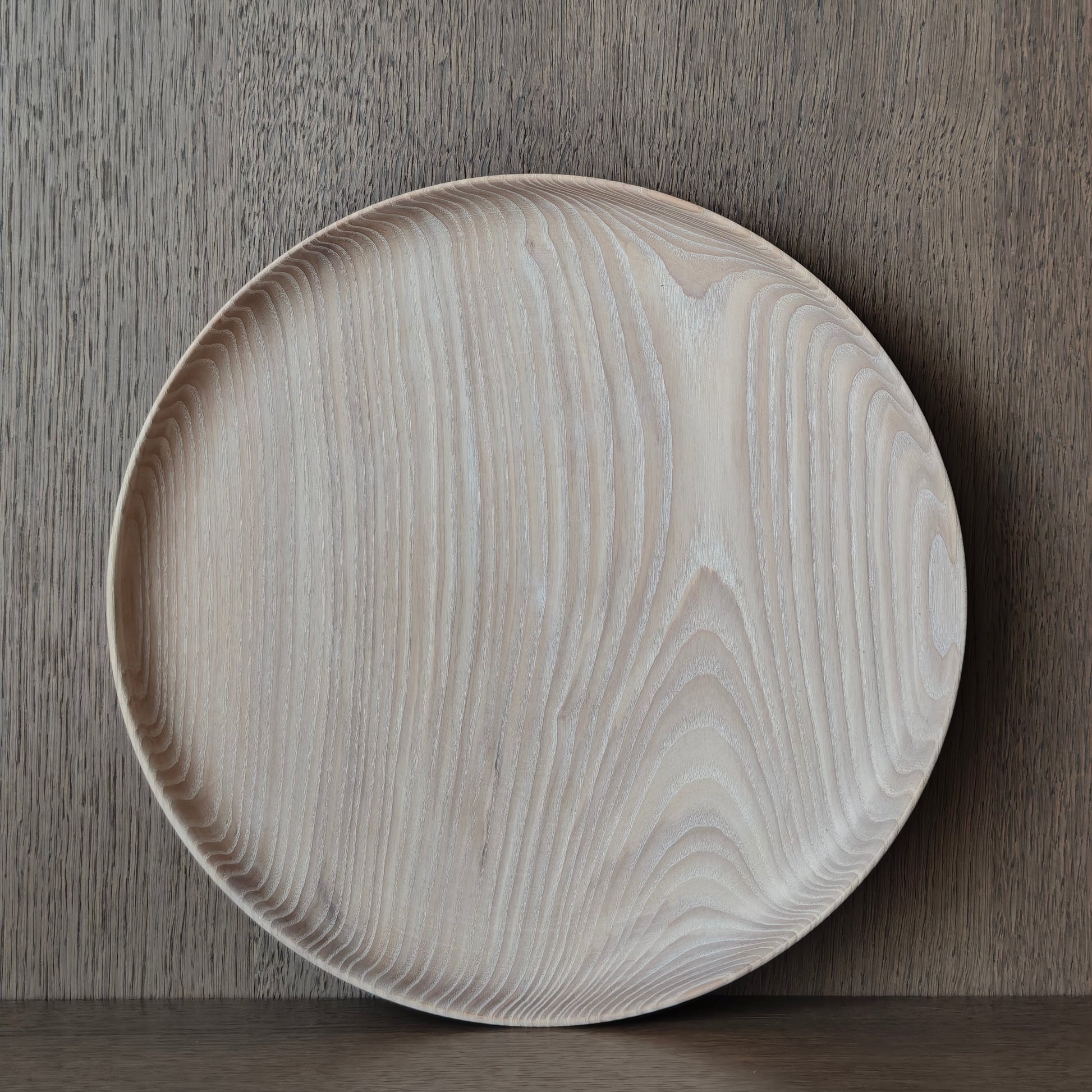 Round wooden tray with wood grain exposed on a wooden surface