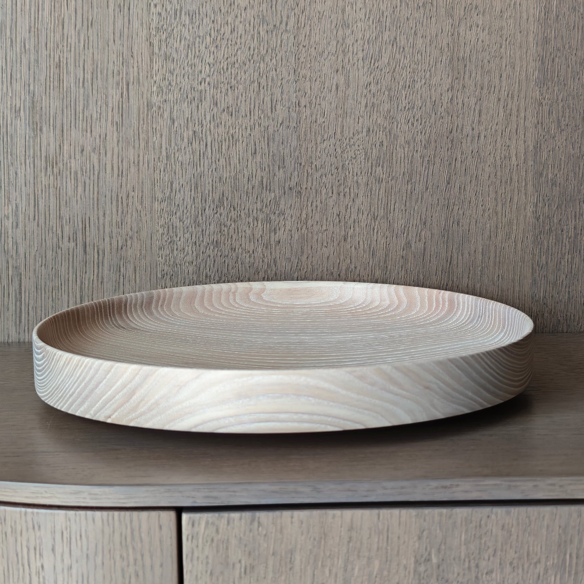 Round wooden tray on a wooden surface with a neutral background